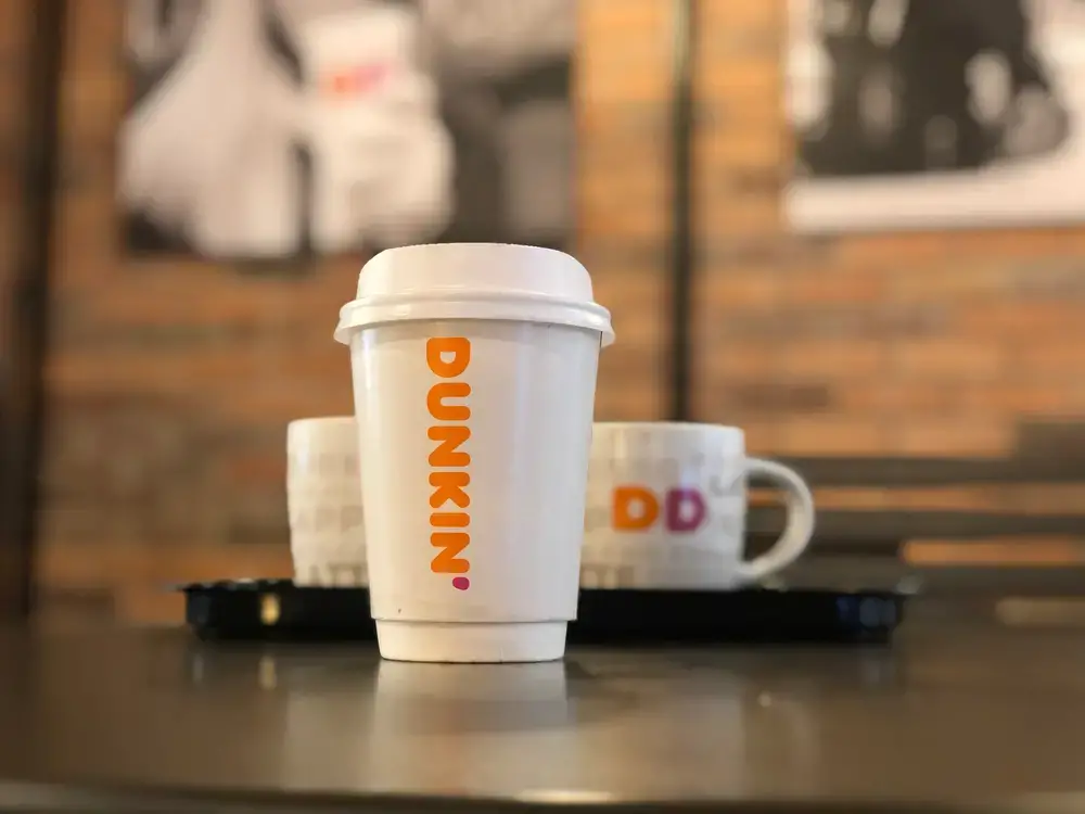 Dunkin-to-go-cup-of-coffee-with-dine-in-mugs-in-background